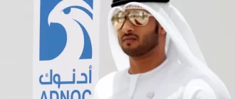Чоловік з ОАЕ біля логотипу компанії ADNOC у місті Рувайс, Об'єднані Арабські Емірати, 14 травня 2018 року / Фото Reuters